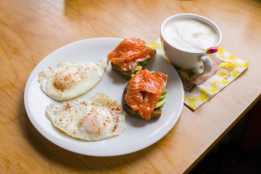 Yağda yumurta, sandviç, avokado ve balıkla kahvaltı..