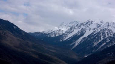 Dağ manzarası. Hava bulutlu. Rusya, Soçi 'de dağ zirvelerinde kar yağıyor..