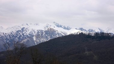 Dağ manzarası. Hava bulutlu. Rusya, Soçi 'de dağ zirvelerinde kar yağıyor..