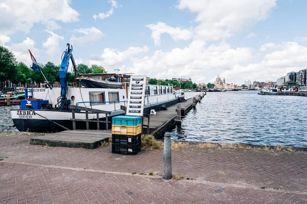 Houten steiger en boot tegen Amsterdam-stadsgezicht — Stockfoto