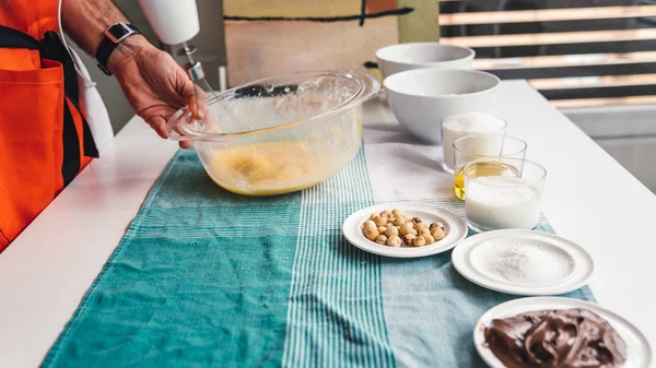 Man förbereder en hemmagjord tårta med choklad och hasselnötter — Stockfoto