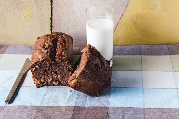 Chokladkaka med ett glas mjölk över bordsduk — Stockfoto