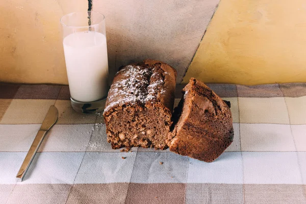 Chokladkaka med ett glas mjölk över bordsduk — Stockfoto