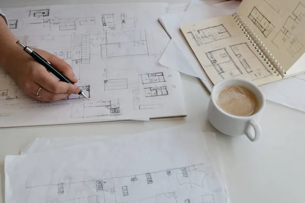 Young female architect working on sketches with a cup of coffee — Stock Photo, Image