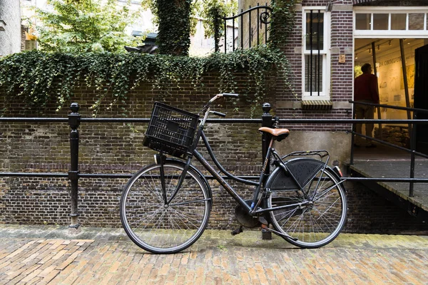 Велосипед припаркован у канала на живописной улице в Голландии — стоковое фото