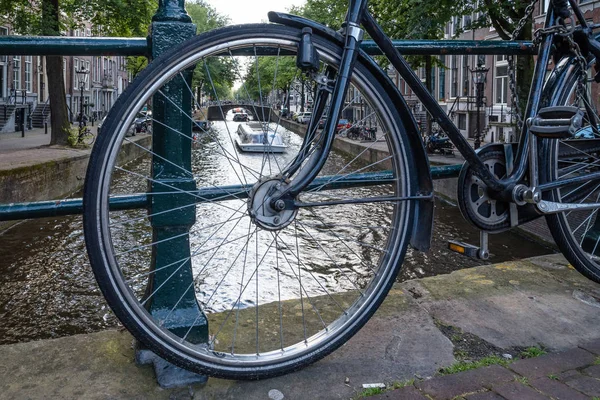 Canal view w Amsterdamie, zobacz za pomocą koła roweru zaparkowany na br — Zdjęcie stockowe
