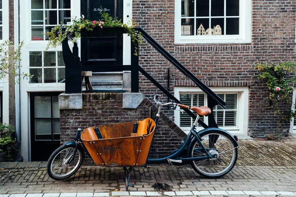 Stary rower vintage zaparkowany przed domem w Amsterdam — Zdjęcie stockowe