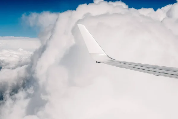 Wing of an airplane flying above the clouds — Stock Photo, Image