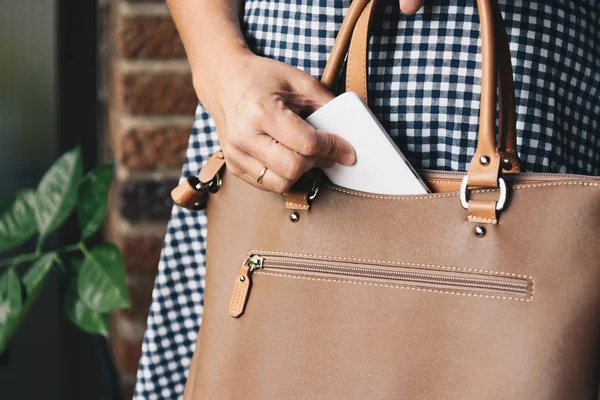 Şık kadın çanta dışında cep telefonu alarak portre fotoğrafı.