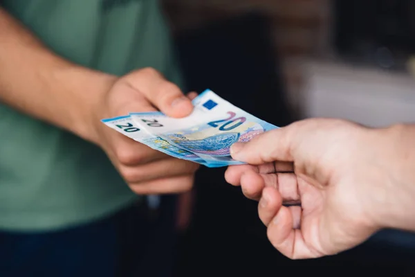 Рука жінки дає молодому чоловікові євро гроші — стокове фото
