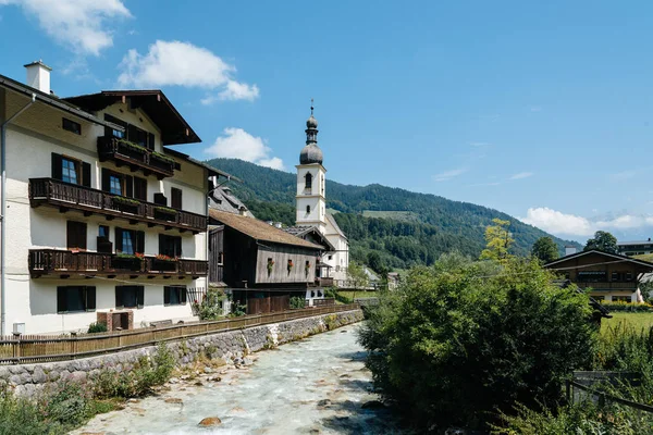 Küçük köy ve beyaz kilise Alplerde doğal görünümünü