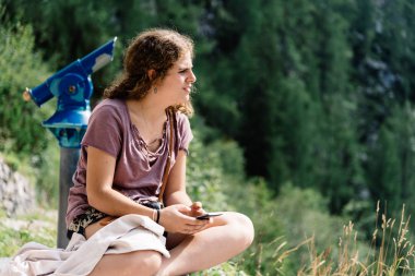 Manzaraya bakarak ve görünümde oturan genç kadın portresi