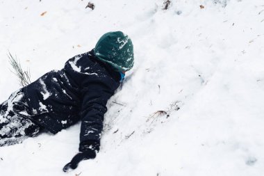 Genç çocuk dağda kar ile eğleniyor