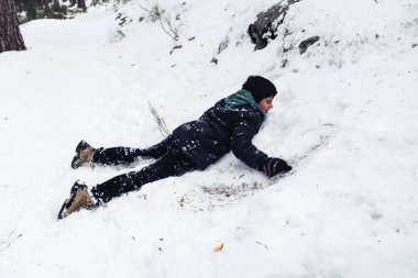 Genç çocuk dağda kar ile eğleniyor