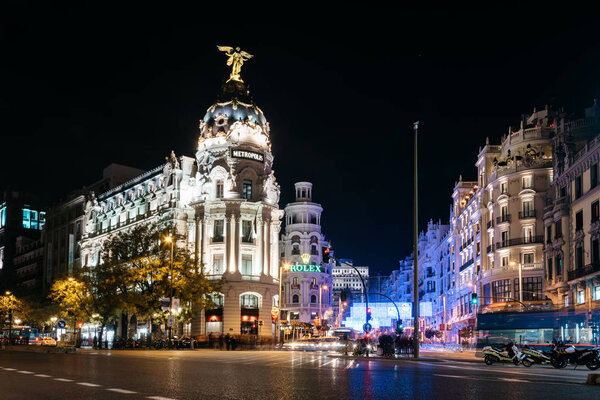 Madrid, Spain - December 8, 2017: Gran Via and Alcala streets in Madrid at night on Christmas time. Long exposure shot with light trails of traffic and blurred people