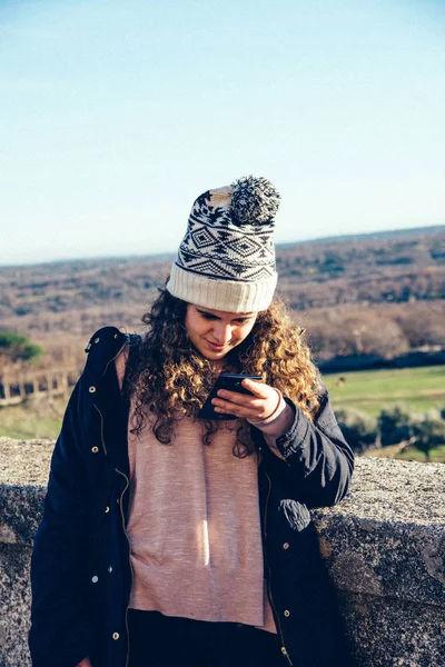 Örgü şapka manifatura cep telefonu ile genç kız