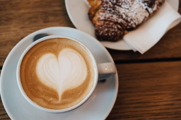 Coffee with latte art heart and fresh baked croissant — Stock Photo, Image