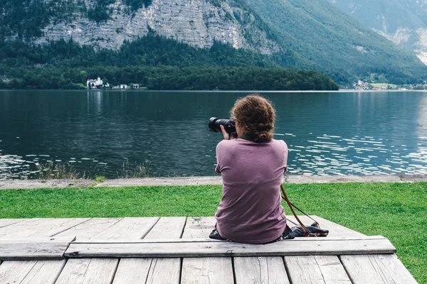 stock image Woman sitting back on pier at lakeside