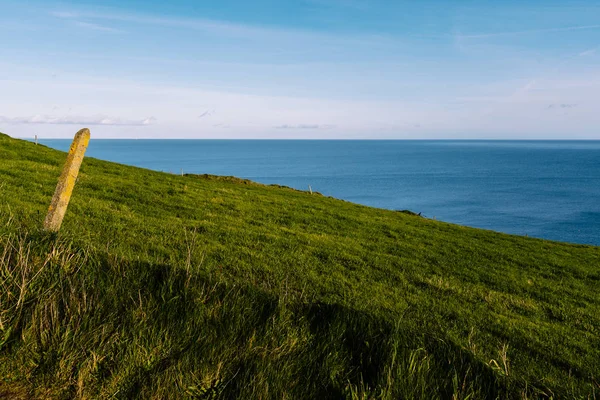 Vista panoramica di erba verde collina e Oceano Atlantico in Irlanda co — Foto Stock