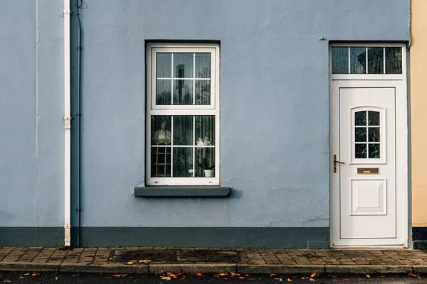 stock image Entrance to old house with white door and window on blue painted