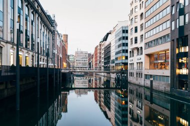Hamburg 'daki Bleichenfleet kanalı manzaralı lüks moda mağazaları akşamları suyu yansıtıyor.