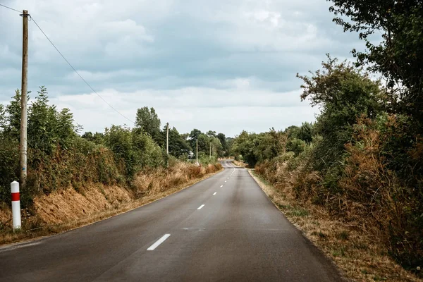 Picturesque country road in Normandy a cloudy day of summer — Stock Photo, Image