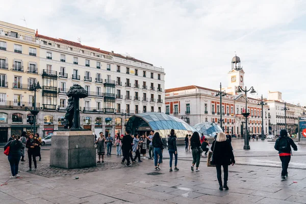 Plaza Puerta del Sol con la famosa escultura Oso y Arbuto y turistas tomando fotos —  Fotos de Stock