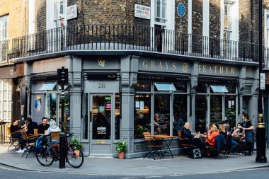 İnsanlar Londra 'da Covent Garden' da bir şarap barında eğleniyorlar.