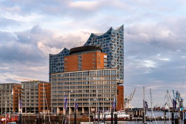 Hamburg limanında Elbphilharmonie ya da Elbe Filarmoni Salonu ve HafenCity 'deki diğer binalarla günbatımı