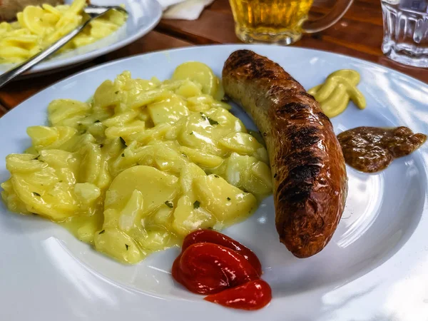 Typické německé jídlo s klobásami, hořčicí, rajčatovým kečupem a bramborovým salátem — Stock fotografie