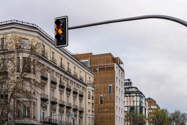 Semáforo amarillo en la ciudad y paisaje urbano en el fondo — Foto de Stock