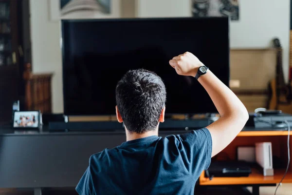 Tiener zitten op de vloer thuis spelen van een video game op de console — Stockfoto