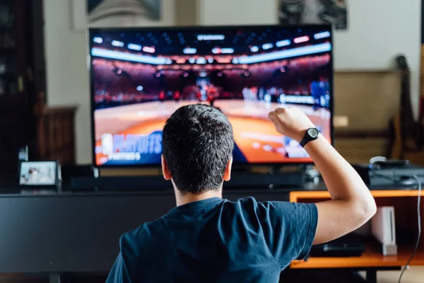 Tiener zitten op de vloer thuis spelen van een video game op de console — Stockfoto