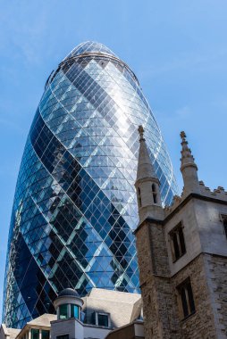 Londra 'daki ofis binalarının alçak açılı görüntüsü mavi gökyüzüne karşı. Gherkin.