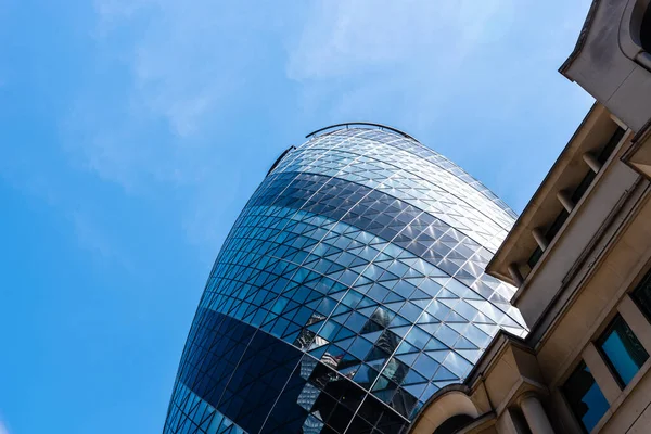 Vista de baixo ângulo de edifícios de escritórios na cidade de Londres contra o céu azul. Gherkin. — Fotografia de Stock