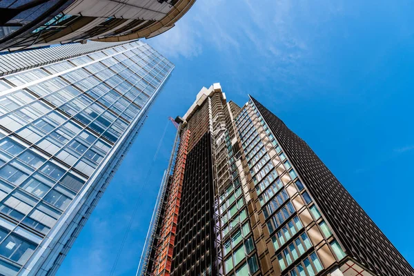Londra şehrinde mavi gökyüzüne karşı inşaat halindeki ofis binalarının alçak açılı görüntüsü. — Stok fotoğraf
