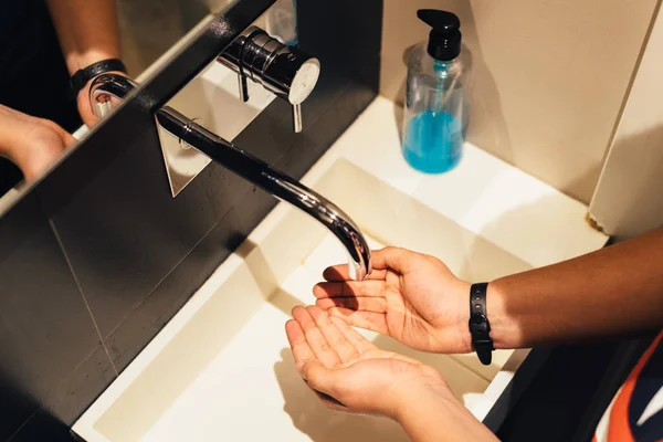 Close-up van de jongeman wassen handen met zeep onder badkamer wastafel. Preventie van gezondheidsbescherming tijdens griepvirus of coronavirus COVID-19 pandemie — Stockfoto