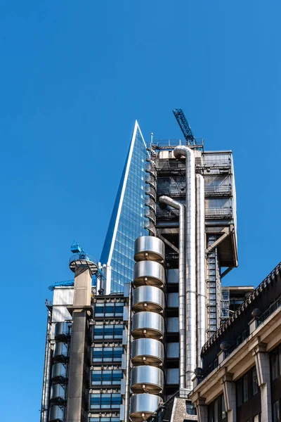 Londra şehrindeki Lloyds binasının alçak açılı görüntüsü mavi gökyüzüne karşı — Stok fotoğraf