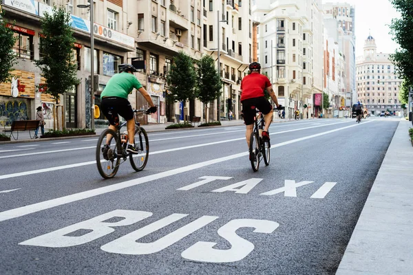 Ciclistas montando en una vacía avenida Gran Vía durante el bloqueo pandémico de Covid-19 en Madrid —  Fotos de Stock