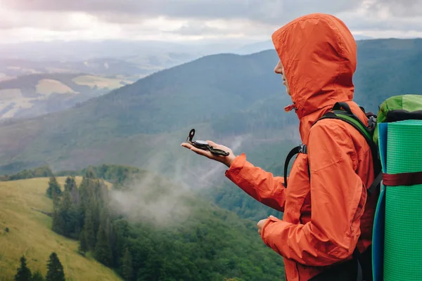 Vrouw met behulp van kompas tijdens het wandelen in berg — Stockfoto