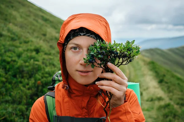 Женщина путешествует в горах и наслаждается вкусом местной черники — стоковое фото