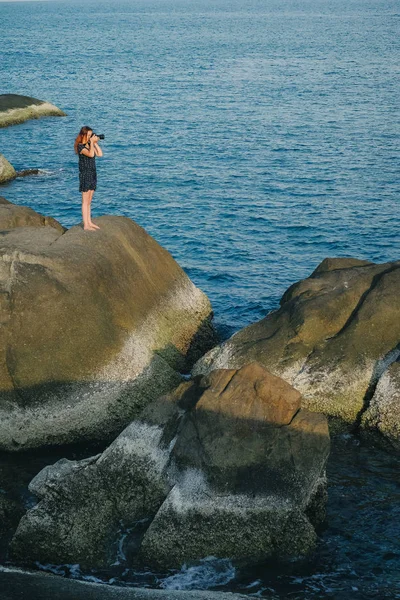 Femme prenant des photos de la belle mer bleue de la falaise — Photo