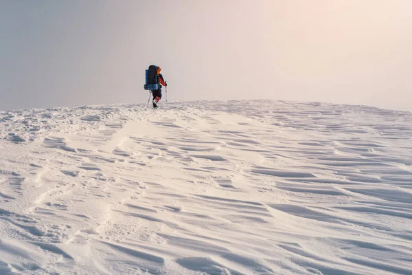男人用背包和雪在冬天山徒步 — 图库照片
