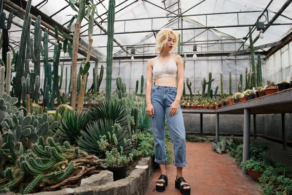 Hermosa mujer rubia posando en el jardín botánico tropical — Foto de Stock