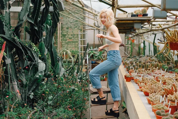 Scène drôle de femme marchant entre cactus et plantes succulentes — Photo