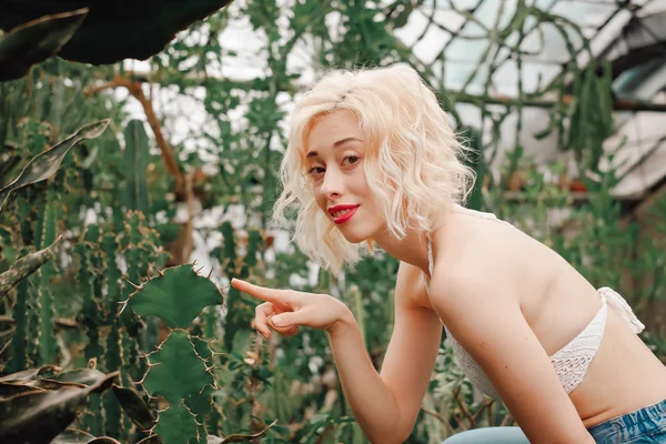 Funny portrait of beautiful blonde woman between barbed cactus — Stock Photo, Image