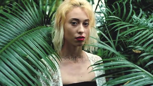 Mild porträtt av blond kvinna i tropiska botaniska trädgård — Stockvideo