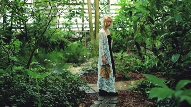 Beautiful blonde woman walking in green tropical forest — Stock Video