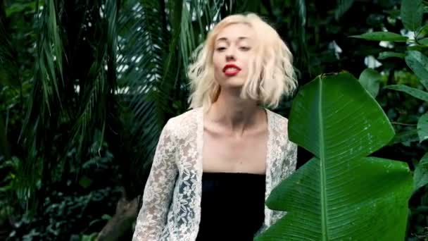 Beautiful blonde woman walking in green tropical forest — Stock Video