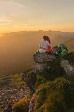 Genç çift keyfini beraber dağlarda güzel gün batımı